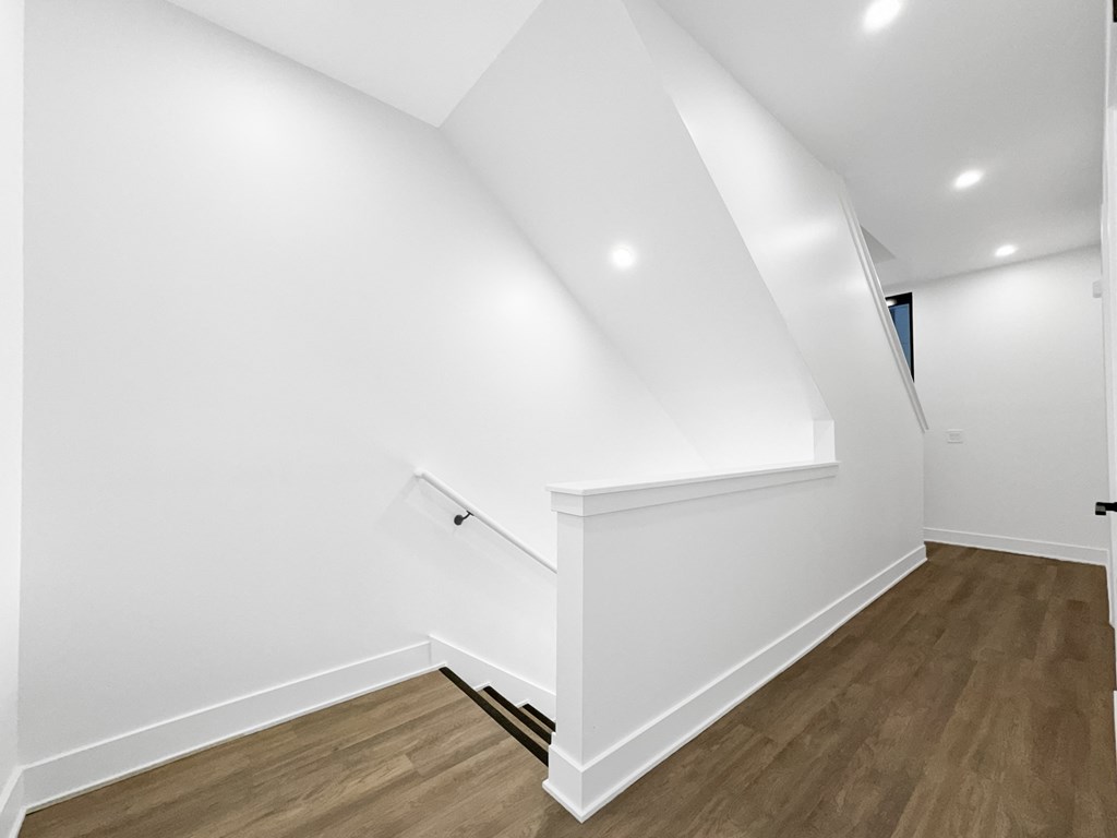 a living room with white walls and a wooden floor