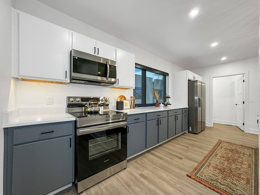 a kitchen with blue cabinets and a stove and a microwave