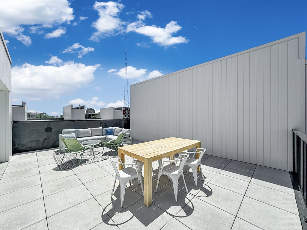 a patio with a table and chairs on a roof