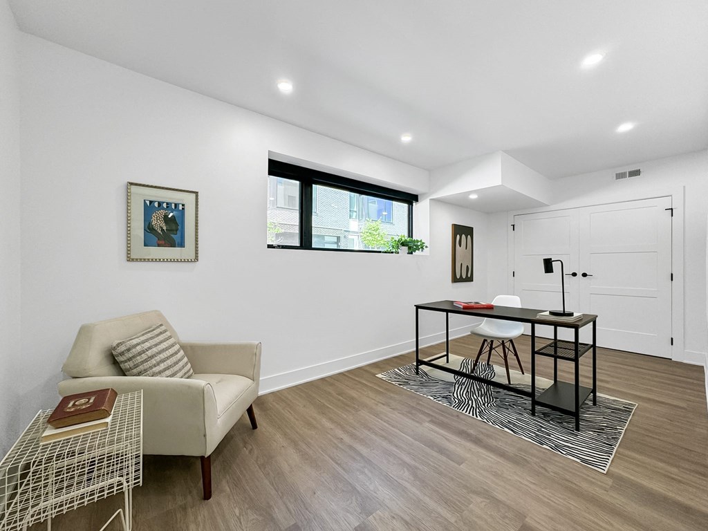 a living room with white walls and a table with a chair
