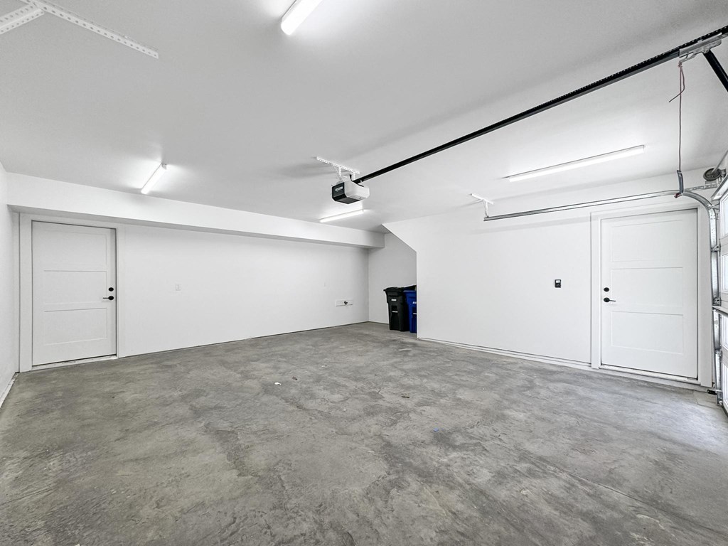 the interior of a garage with white walls and a concrete floor