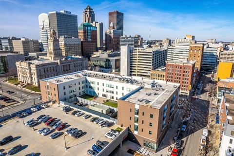 A cityscape with a large building in the foreground and several other buildings in the background.
