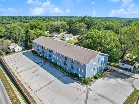 A large blue building with a parking lot in front.