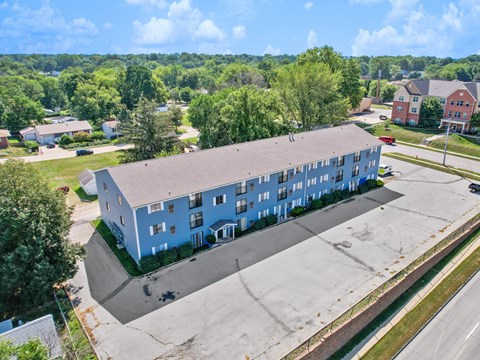 A large blue building with a parking lot in front of it.