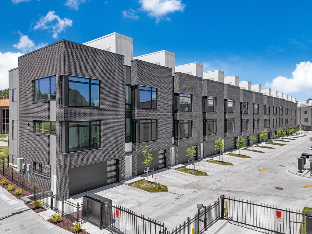 a row of brick apartment buildings with a parking lot
