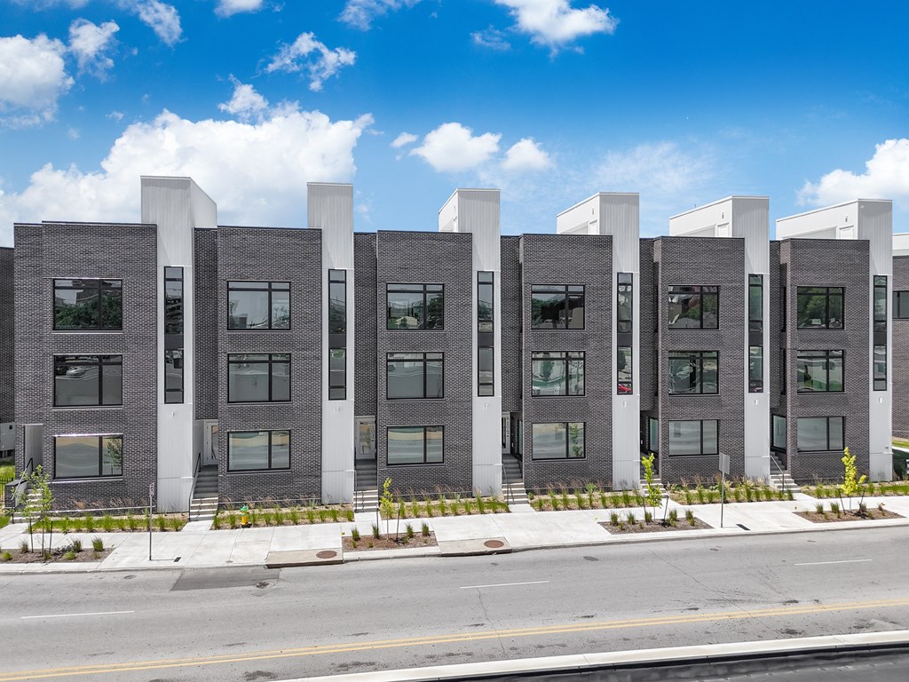 a group of modern apartment buildings on the side of a street