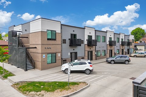 A modern building with a parking lot in front.