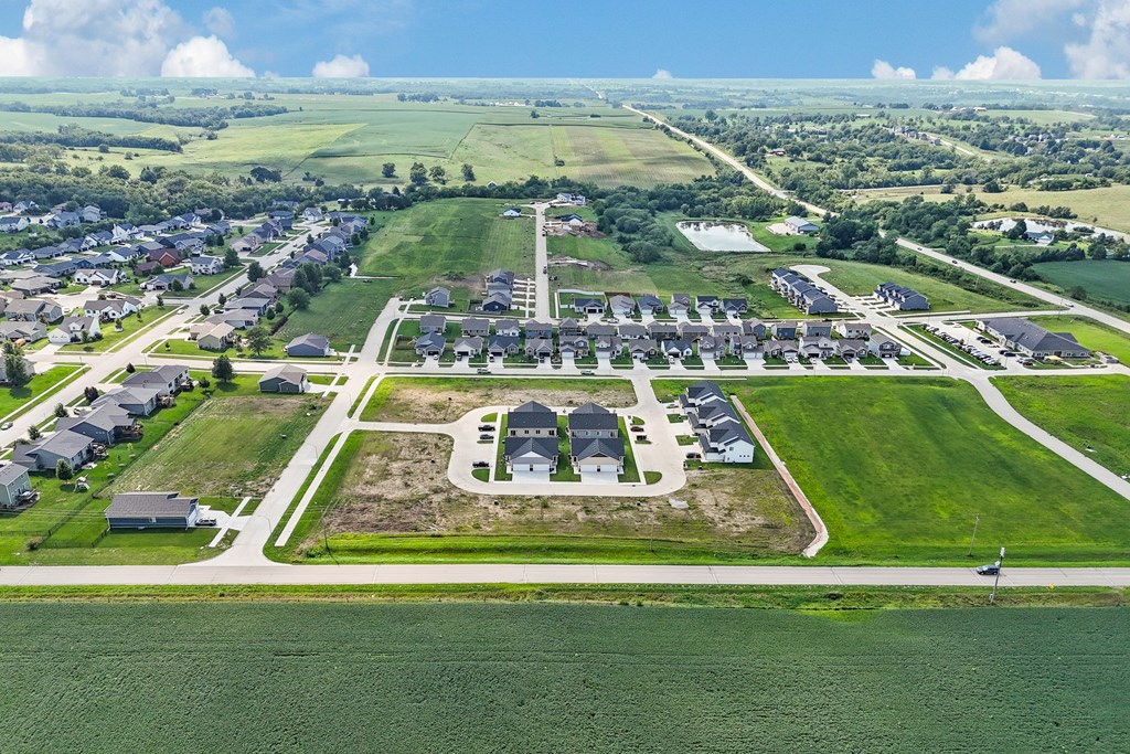 A bird's eye view of a residential area with a large green field in the foreground.