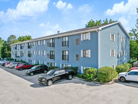 A blue building with a parking lot in front of it.