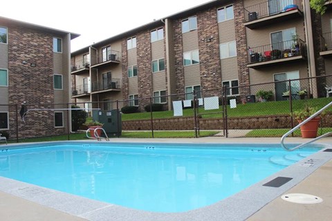 A swimming pool in front of apartment buildings.
