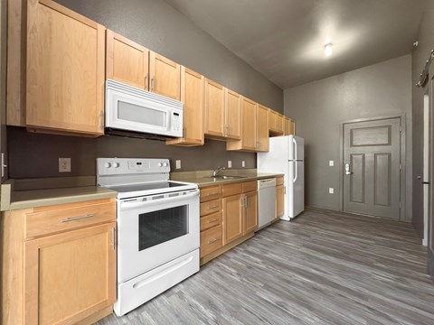A kitchen with wooden cabinets and white appliances.