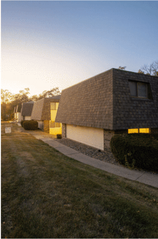 A modern house with a dark roof and bright windows is shown.