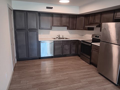 A kitchen with wooden floors and stainless steel appliances.