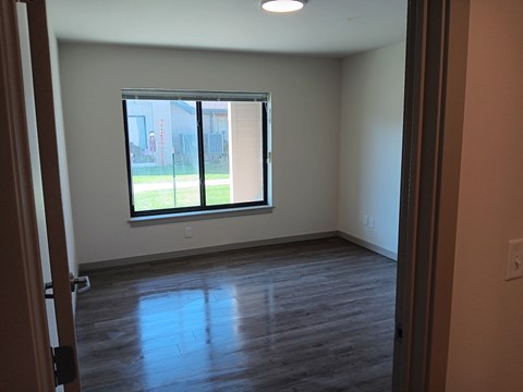 A room with a window and wooden flooring.
