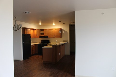 A kitchen with wooden cabinets and a black refrigerator.