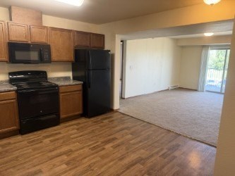 A kitchen with black appliances and wooden cabinets.