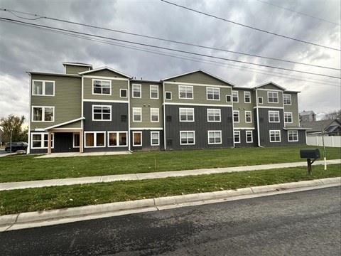 Apartment building with grey and white exterior on a cloudy day.