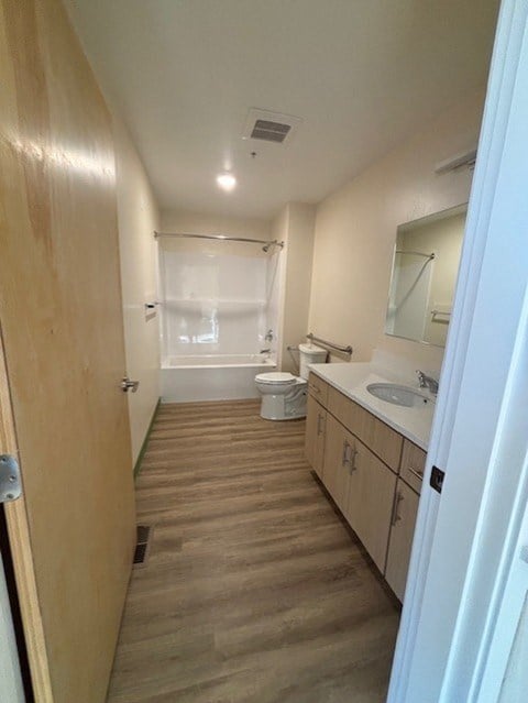 A small bathroom with a toilet, sink, and shower.