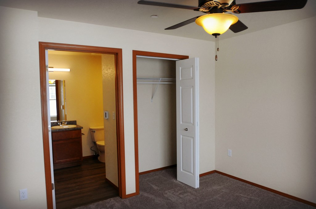 Bathroom/Closet Image showing toile and bathroom sink next to closet with hanger racks