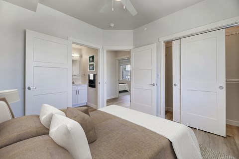 A bedroom with a bed and a ceiling fan.