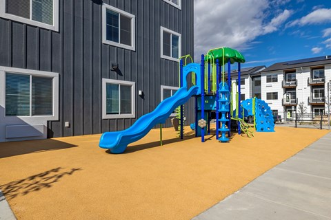 A playground with a blue slide and a green top.