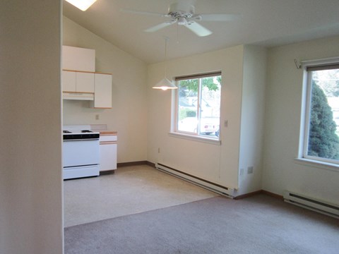 an empty kitchen with a ceiling fan and a window