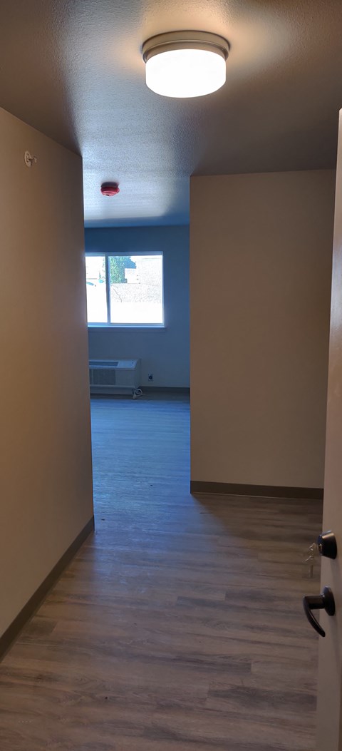an empty room with an open door and a window