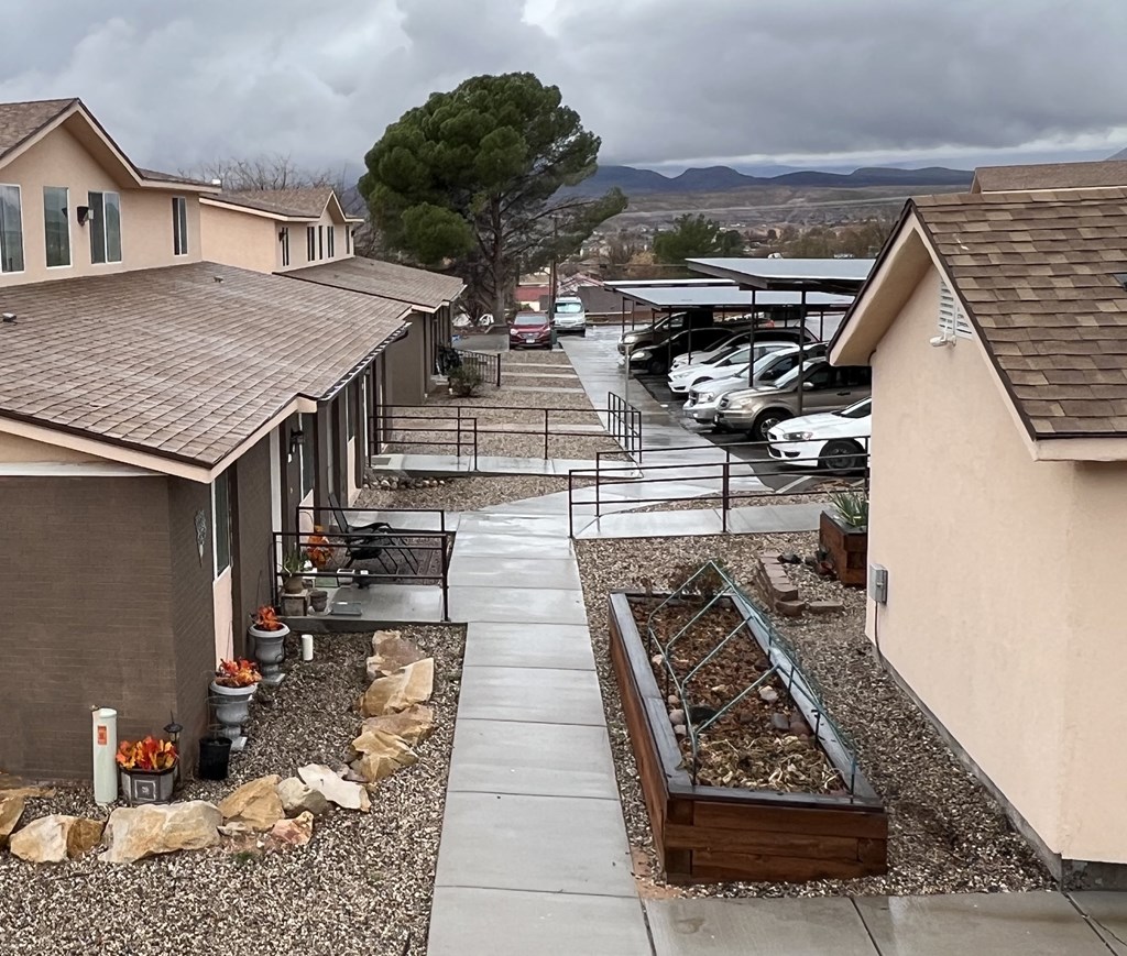 view of property showing units and raised garden beds