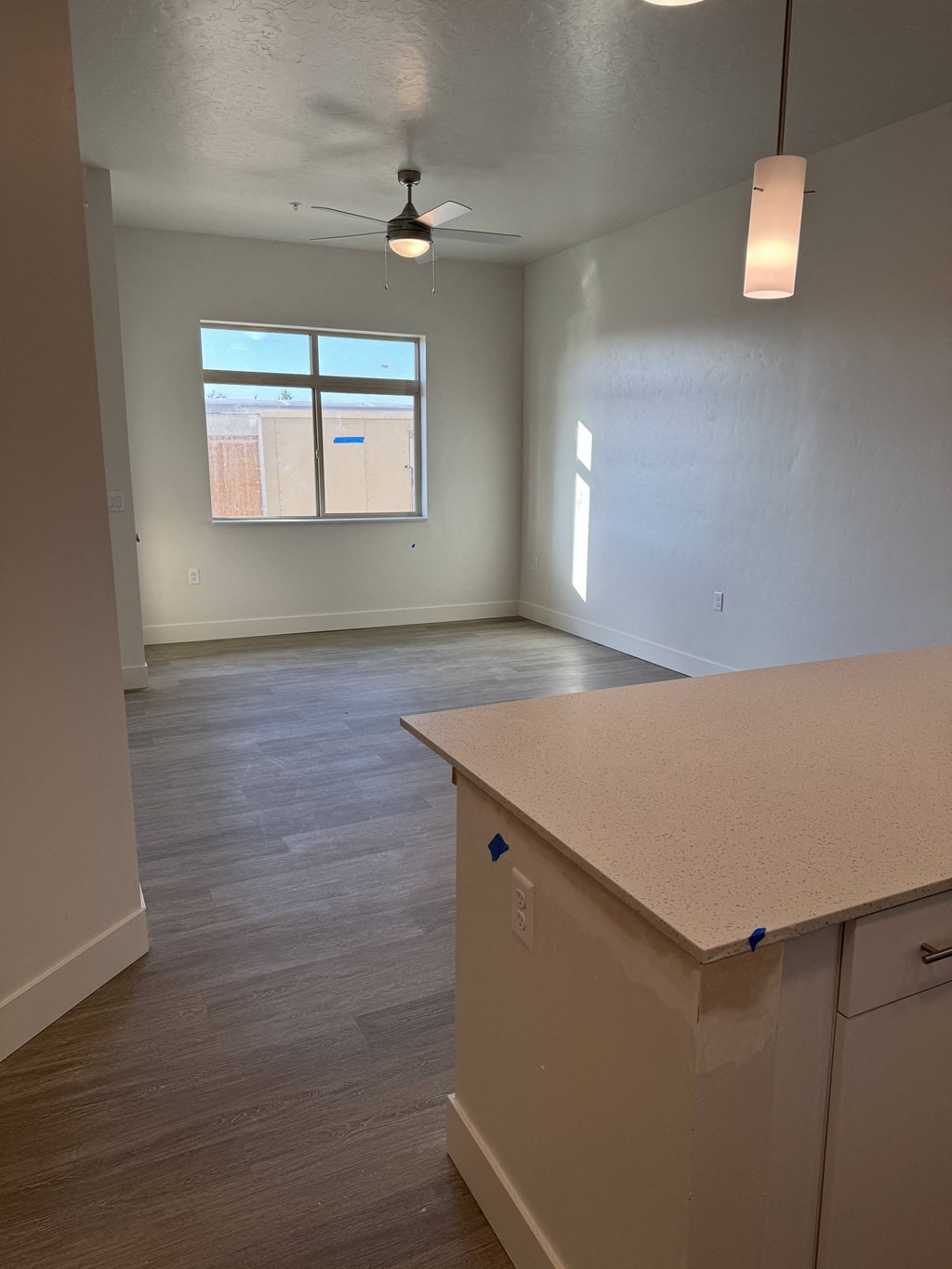 a kitchen and an empty living room with a window