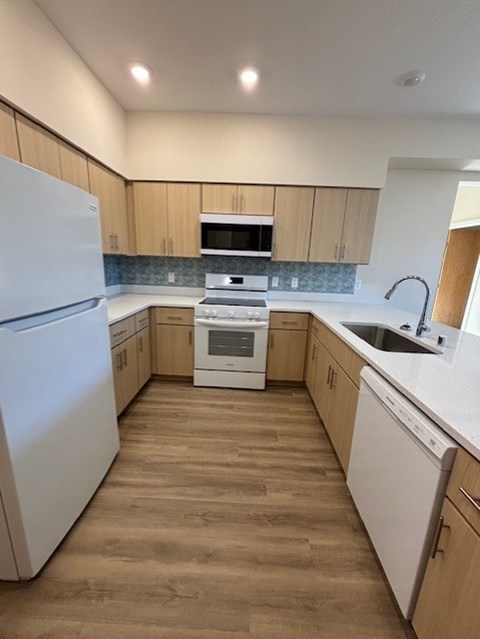 A kitchen with wooden cabinets and a white fridge.