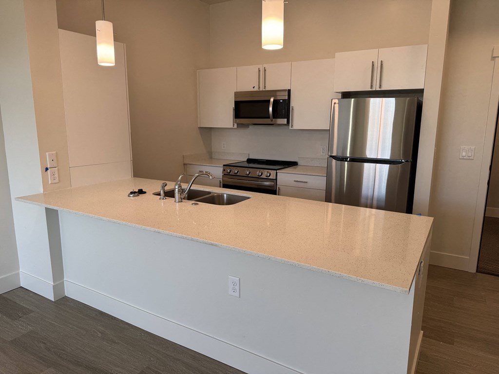 a kitchen with a counter top and a stainless steel refrigerator