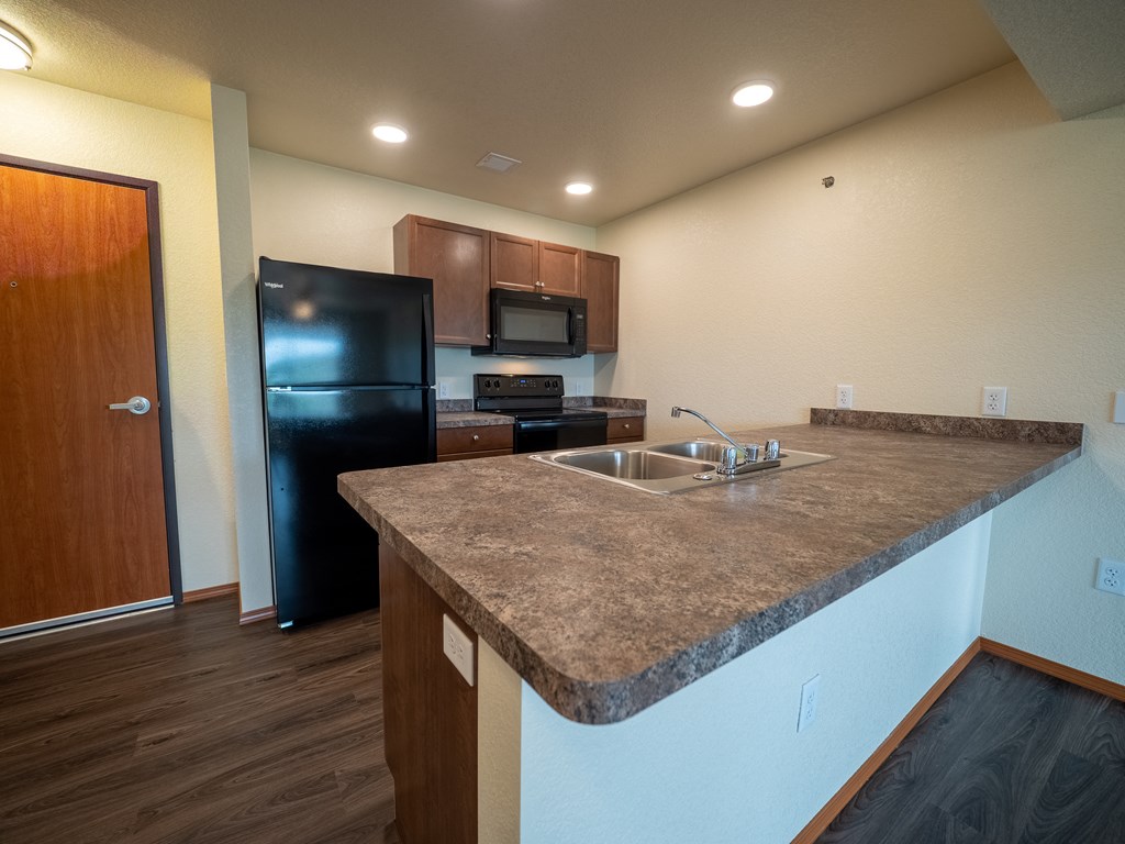 Image of refrigerator, sink, stove,  microwave, and cabinets