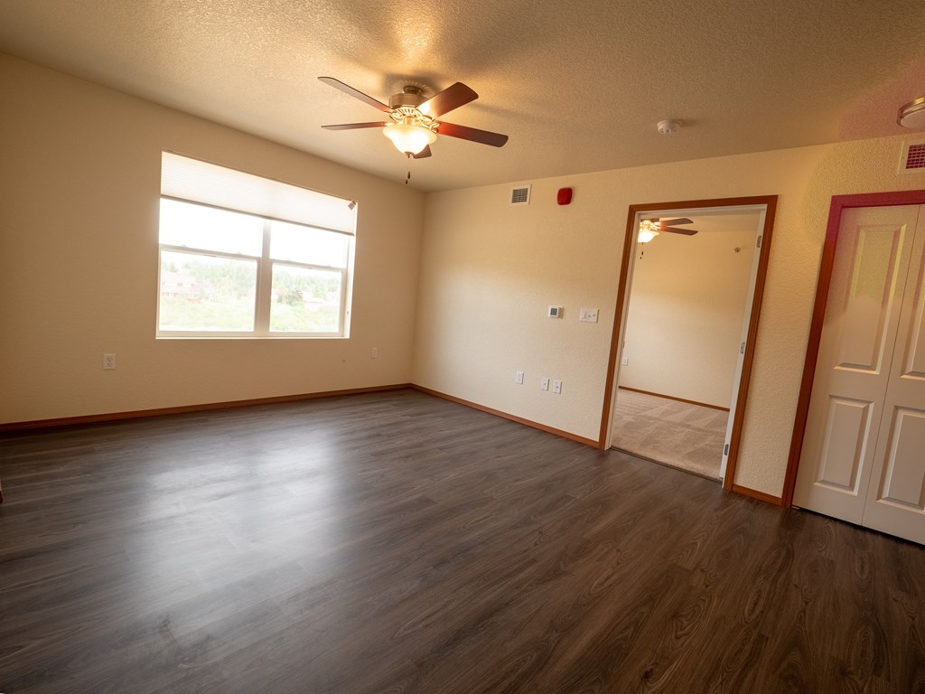 Image of living space with overhead fan and a window