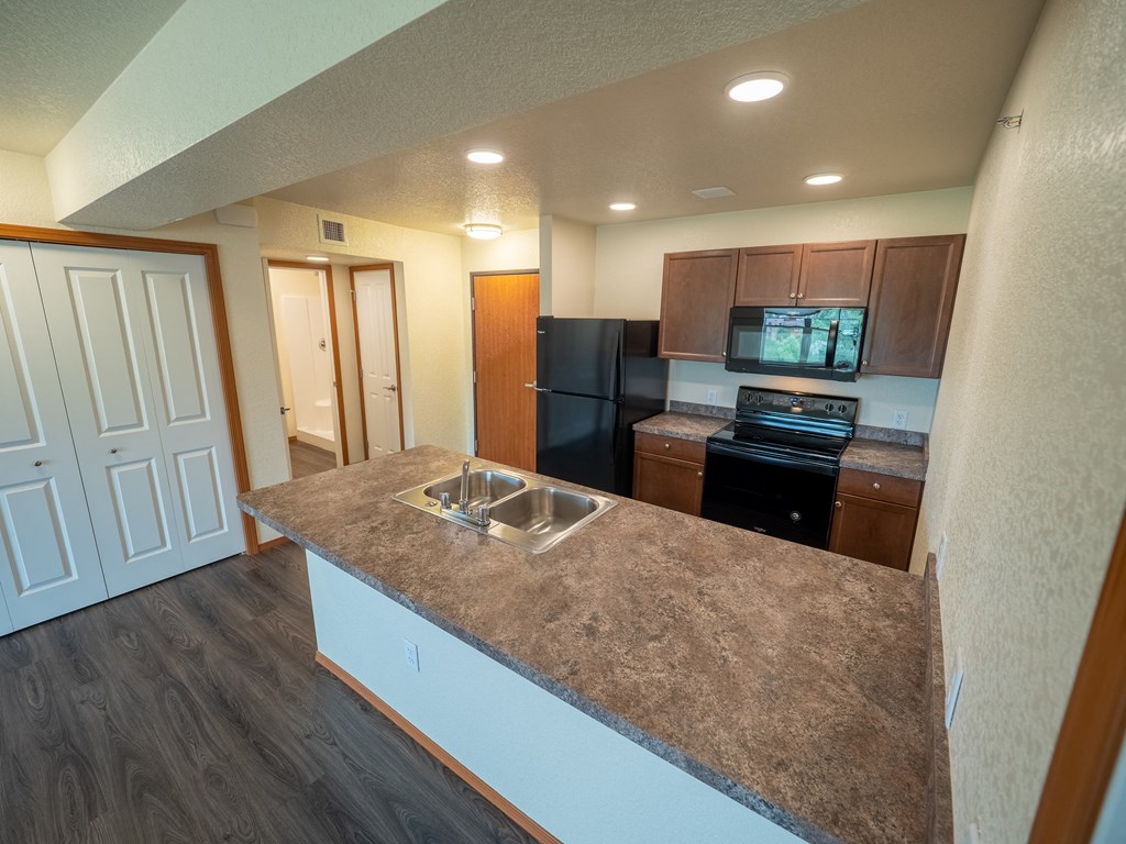 Image of refrigerator, sink, stove,  microwave, and cabinets