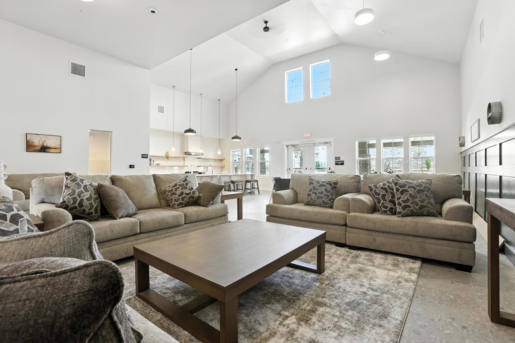 A spacious community room with a large sectional sofa and a coffee table.