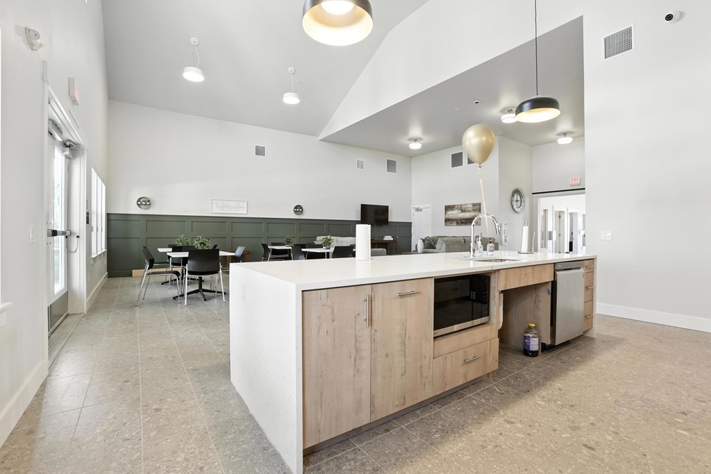A community room kitchen with a large island and a dining table.