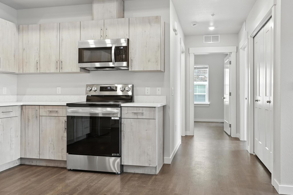 A modern kitchen with a stainless steel oven and microwave.