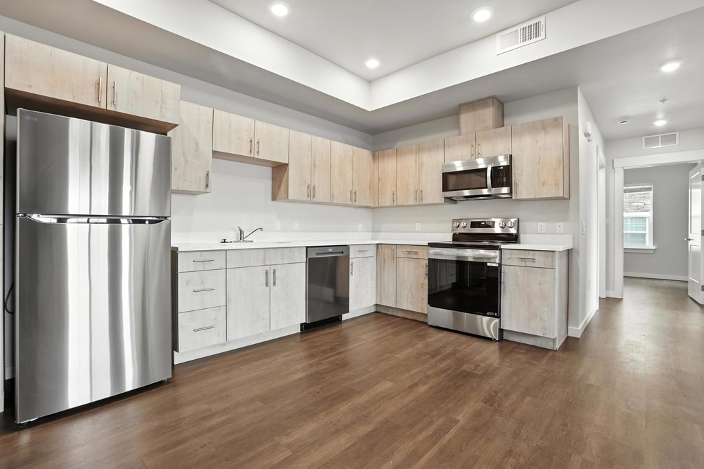 A modern kitchen with wooden cabinets and stainless steel appliances.