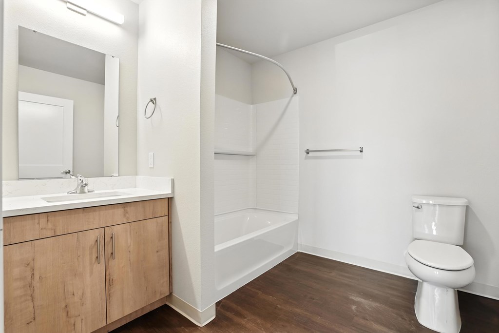 A white bathroom with a toilet, sink, and bathtub.