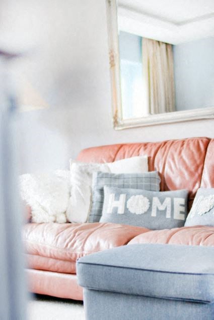 A couch with a pillow that says "HOME" on it.