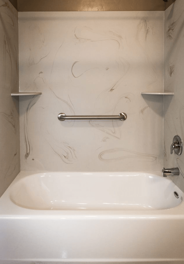 a white bathtub in a bathroom with grab bars