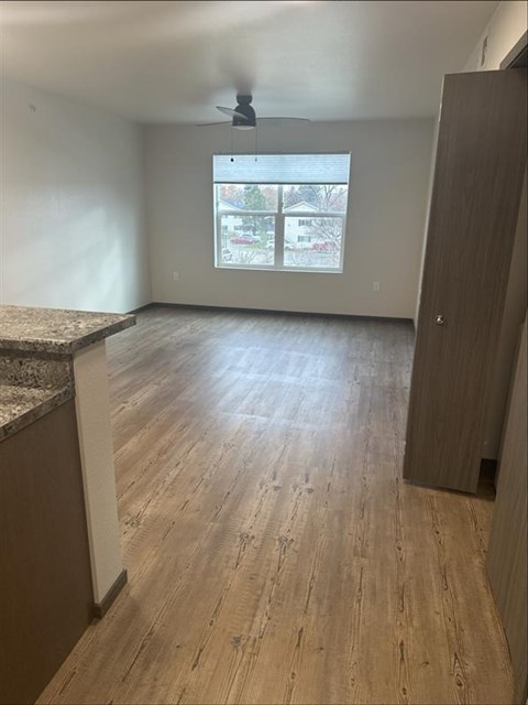 A room with wooden flooring and a ceiling fan.