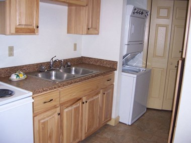 Image of stove, cabinets, sink, washer, and dryer