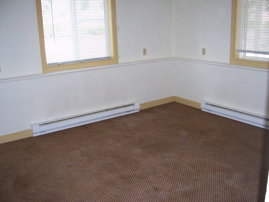 Image of space with two baseboard heaters and windows