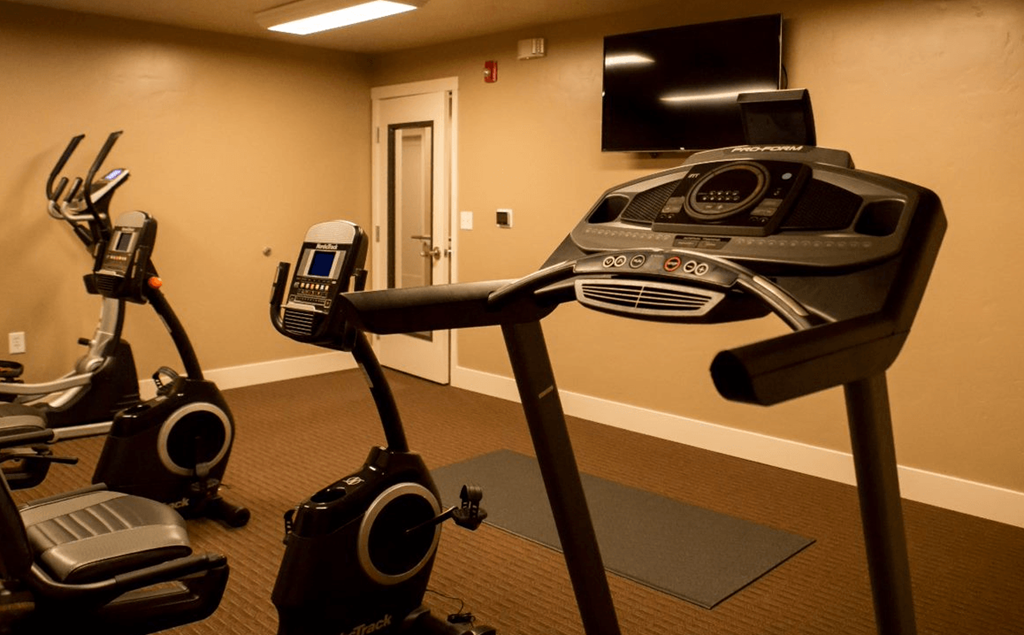 fitness center with exercise machines and a flat screen tv