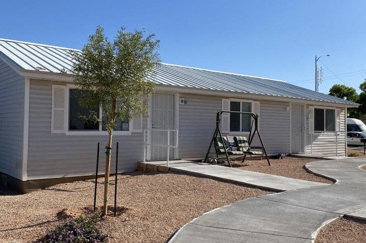 outside of a unit with sidewalks and a tree