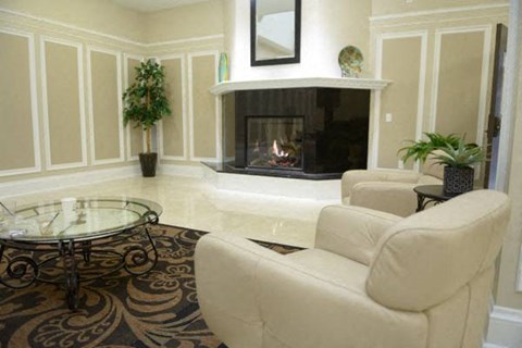 a living room with white furniture and a fireplace