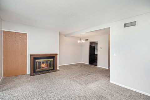 a living room with a fireplace and a carpeted floor