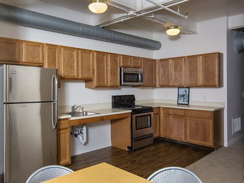 a kitchen with wooden cabinets and a stainless steel refrigerator