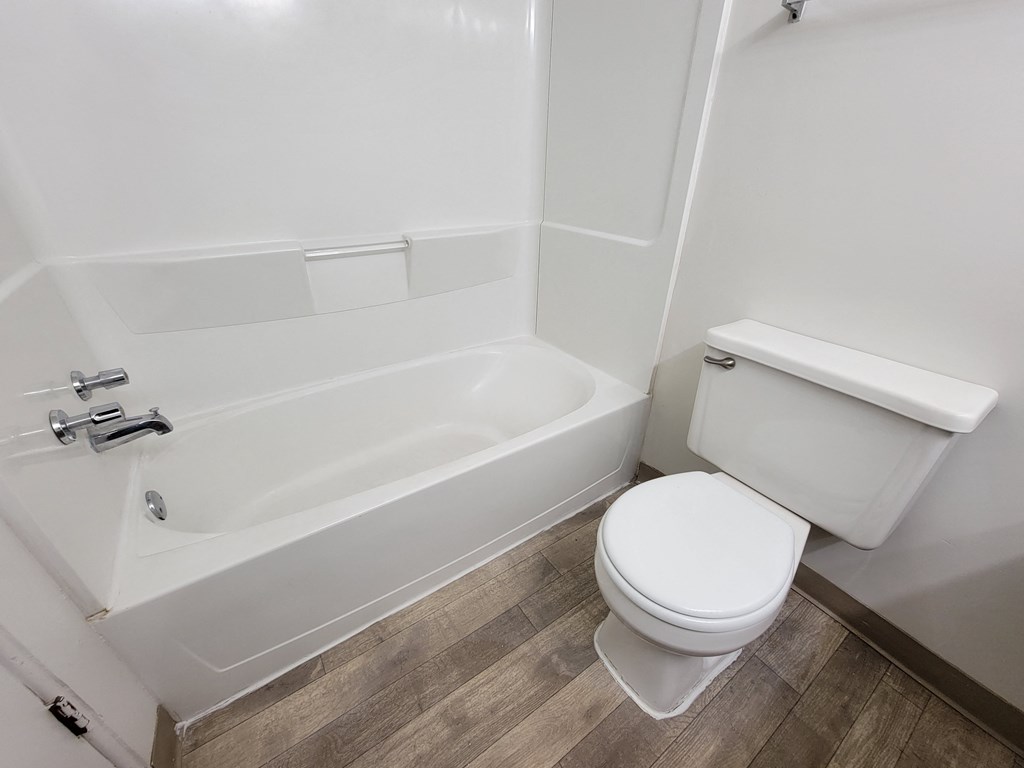 Clean and spacious bathroom with bathtub and toilet at Garfield Commons Apartments in Clinton Township, MI